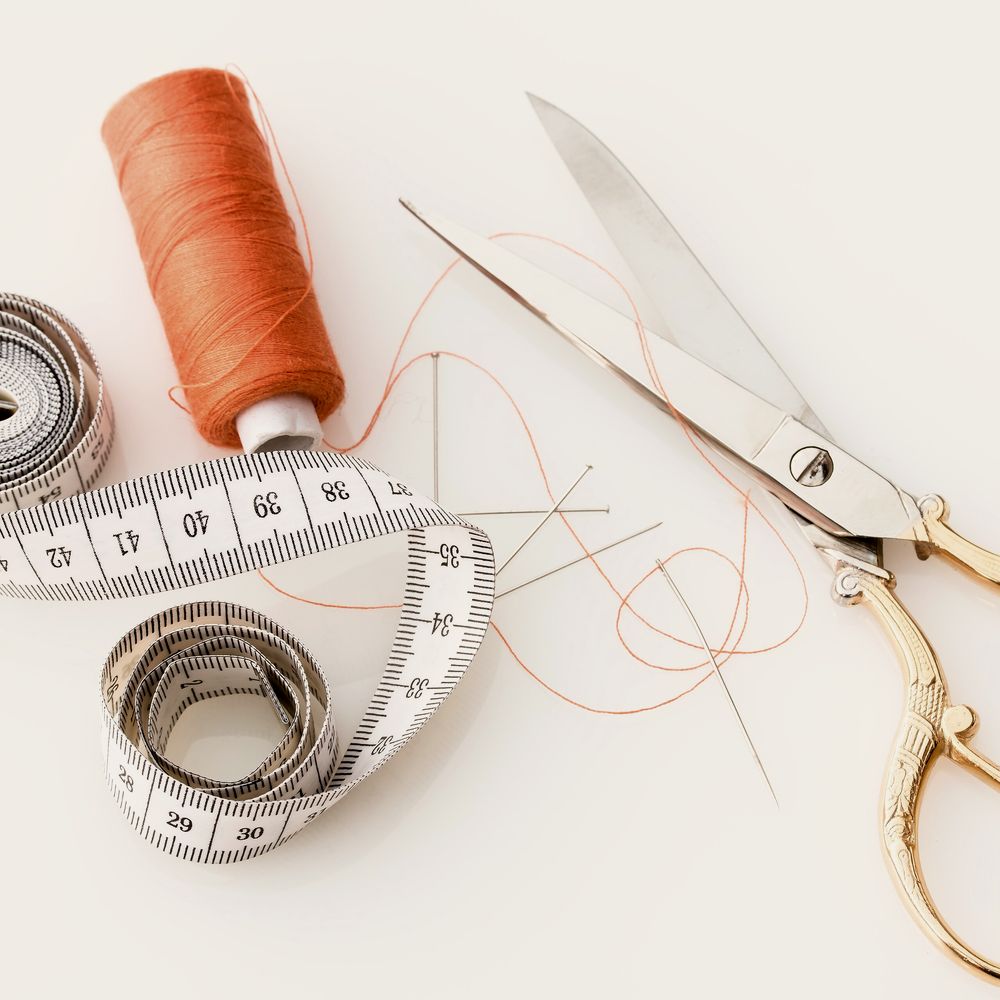 A tailor’s tape measure, thread and shears